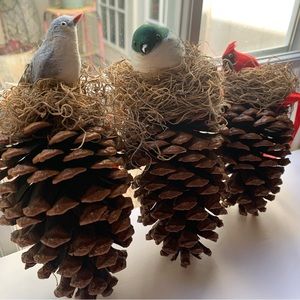 Handmade Christmas bird ornaments on pine cones & straw hanging from red ribbon